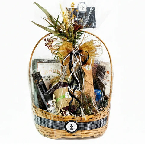 Cesta gourmet Maria Madame com vinho, chocolates e flores, embalada para presente.