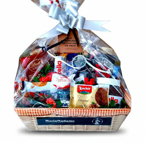 Cesta gourmet Maria Madame com chocolates Lindt, Raffaello, Nutella, biscoitos e laço decorativo.